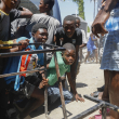 Un grupo de menores busca resguardo tras escuchar disparos en una escuela pública que sirve como refugio para la población que ha sido desplazada por la violencia de pandillas, en Puerto Príncipe, el 22 de marzo de 2024.
