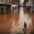 Un hombre camina por una calle inundada debido a las intensas lluvias