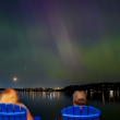 Un grupo de personas admira la aurora boreal que ilumina el lago Washington