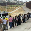 Migrantes que buscan asilo se forman mientras esperan ser procesados luego de cruzar la frontera desde México, el miércoles 5 de junio de 2024, en San Diego, California