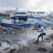 Pescadores tiran de un barco dañado por el huracán Beryl de regreso al muelle en Bridgetown Fisheries en Barbados, el lunes 1 de julio de 2024.