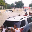Estos jóvenes dan “una mano” al conductor de este vehículo, sacándolo de un atasque en un gran cúmulo de agua en una avenida de Santo Domingo.