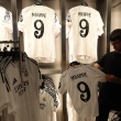 Un hombre sostiene la camiseta recién lanzada del futbolista francés Killyan Mbappé en la tienda oficial del Real Madrid en el estadio Santiago Bernabeu de Madrid el 11 de julio de 2024.