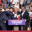 El candidato presidencial republicano, el expresidente Donald Trump, recibe ayuda para bajar del escenario en un evento de campaña en Butler, Pensilvania, el sábado 13 de julio de 2024. (Foto AP/Gene J. Puskar)