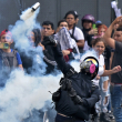 Opositores al gobierno del presidente venezolano Nicolás Maduro se enfrentan con la policía antidisturbios ayer, durante una protesta en el barrio Catia de Caracas.