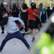 Un manifestante lanza un ladrillo durante una protesta en Liverpool