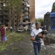 Vecinos de un edificio de apartamentos dañado tras proyectiles ucranianos abandonan la zona en Kursk, Rusia, ayer domingo.