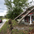 Un automovilista pasa junto a una casa con árboles caídos en el techo después del huracán Helene el 29 de septiembre de 2024 en Rutherfordton, Carolina del Norte.