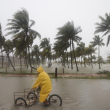 Una persona monta su bicicleta a través de una calle inundada mientras el huracán Milton pasa frente a la costa de Progreso, en el estado de Yucatán, México, el martes 8 de octubre de 2024