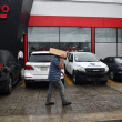 Un hombre se cubre de la lluvia con un pedazo de cartón al caminar por una acera de la capital.