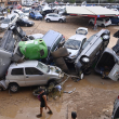 Wreckage of cars and debris are piled up in the streets of Paiporta, on October 31, 2024, covered in mud after flash floods ravaged this area of Valencia region, eastern Spain. - Rescuers raced on October 31, 2024 to find survivors and victims of once-in-a-generation floods in Spain that killed at least 95 people and left towns submerged in a muddy deluge with overturned cars scattered in the streets. About 1,000 troops joined police and firefighters in the grim search for bodies in the Valencia region as Spain started three days of mourning. Up to a year's rain fell in a few hours on the eastern city of Valencia and surrounding region on October 29 sending torrents of water and mud through towns and cities. (Photo by JOSE JORDAN / AFP)