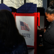 Un votante, a la derecha, llena su boleta durante la votación anticipada en las elecciones generales, el viernes 1 de noviembre de 2024, en Fall River, Massachusetts.