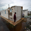 Un joven camina afuera de una casa dañada y rodeado de agua de lluvia después del paso del huracán Rafel en Batabano, provincia de Mayabeque, Cuba, el 7 de noviembre de 2024.