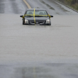 Un automóvil queda varado en una carretera inundada