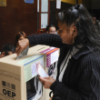 Una mujer deposita su voto en un colegio electoral durante las elecciones judiciales en La Paz el 15 de diciembre de 2024. - Más de 7,3 millones de bolivianos están llamados a votar obligatoriamente este domingo para elegir a sus máximas autoridades de justicia en una elección anómala en la que la mayoría de departamentos no podrán renovar a todos sus representantes.