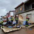 Esta fotografía difundida por la Securité Civile el 15 de diciembre de 2024 y tomada en un lugar no revelado en el territorio francés del océano Índico de Mayotte muestra a miembros de la Seguridad Civil francesa limpiando escombros después de que el ciclón Chido azotara el archipiélago