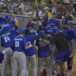 Varios peloteros del Licey rodean a Jorge Alfaro luego de conectar su vuelacercas en el éxito de los azules sobre las Aguilas en el estadio Cibao.