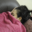 Fotografía muestra a mujer durmiendo en un sofá.