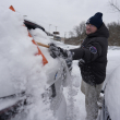 Cary Fallath, técnico de la tienda BMW, limpia la nieve