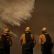 Los bomberos observan las gotas de agua que caen sobre el incendio Palisades