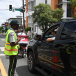 Persona de la Digesett orienta a conductor ante la nueva prohibición de giros a la izquierda en la avenida Tiradentes.