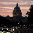 Vista del Capitolio de EEUU al amanecer mientras los autos circulan por la avenida Pensilvania, el 1 de octubre de 2025, en Washington