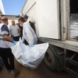 Trabajadores de la morgue descargan los cuerpos de palestinos que habían estado bajo custodia israelí, tras ser transportados en vehículos de la Media Luna Roja y camiones refrigerados, al hospital Nasser de Khan Yunis, en el sur de la Franja de Gaza, el 15 de octubre de 2025. Según el acuerdo de alto el fuego negociado por el presidente estadounidense, Israel debía entregar los cuerpos de 15 palestinos por cada israelí fallecido que regresara.