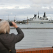 Un miembro del público fotografía al HMS Dragon, un destructor de defensa aér ea de la clase Daring Tipo 45 de la Marina Real Británica, guiado por remolcadores operados por Serco Marine Services desde la Base Naval de Portsmouth, en la costa sur de Inglaterra, el 10 de marzo de 2026.