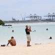 Un señor utiliza su celular para grabar el ambiente en la playa de Boca Chica el Jueves Santo.