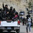 Agentes antidisturbios viajan en la parte trasera de una camioneta durante los enfrentamientos con manifestantes rurales en Bolivia.