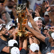 Karl Towns celebra junto a sus compañeros tras sostener el trofeo de campeón de la NBA.