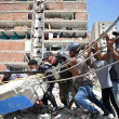 Voluntarios intentan remover escombros mientras buscan cuerpos entre los restos de edificios derrumbados en Catia La Mar, La Guaira,
