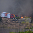 Una fotografía tomada el 10 de julio de 2026 muestra un camión de bomberos en una carretera junto a las llamas, cerca de una caseta de jardín, en la zona de un incendio forestal que causó 11 muertos cerca de Bedar, en el municipio de Los Gallardos (provincia de Almería).