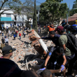 Personas buscan supervivientes entre los escombros de un edificio colapsado tras un terremoto en Cali, Colombia, el 10 de agosto de 2026.