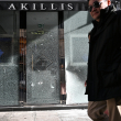 Un peatón pasa junto al escaparate destrozado de una tienda, en el centro de París, el 18 de octubre de 2026, un día después de las protestas a nivel nacional contra el "alto coste de la vida"