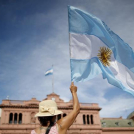 Una manifestante ondea una bandera de Argentina delante de la Casa Rosada durante una protesta contra el presidente del país, Alberto Fernández, y su gestión de las vacunas contra el COVID-19, en Buenos Aires, Argentina, el 27 de febrero de 2021. (AP Foto/Natacha Pisarenko)