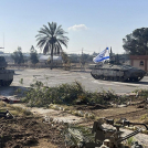 En esta imagen, proporcionada por las Fuerzas de Defensa de Israel, un tanque con una bandera israelí entra al lado gazatí del paso fronterizo de Rafah, el 7 de mayo de 2024.