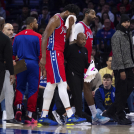 Joel Embiid se coloca una toalla en la cara luego de ser golpeado luchando un rebote.