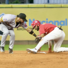 José Caballero trata de poner out a Jean segura, quien se embasó con un doblete para el Escogido