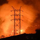 Se ven llamas y humo cerca de líneas eléctricas mientras el incendio de Palisades crece cerca del vecindario de Mandeville Canyon y Encino, California.