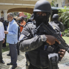 Guardias de seguridad observan mientras el primer ministro de Haití, Alix Didier Fils-Aime, en el centro, conversa con el encargado de negocios de México, Jesús Cisneros, en Puerto Príncipe, Haití, el jueves 26 de junio de 2025.