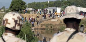 Soldados de República Dominicana en la orilla del río Masacre, una frontera natural con Haití, mientras observan a trabajadores de construcción en el lado haitiano, desde Dajabón, República Dominicana, el viernes 15 de septiembre de 2023.