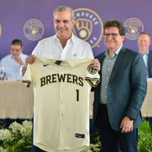 El presidente de la República, Luis Abinader, junto al propietario de los Cerveceros, Mark Attanasio.
