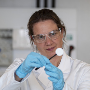 Meike Heinz, investigadora de Empa, examina una muestra del electrolito cerámico sólido. Foto Empa.