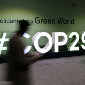 Los asistentes pasan junto al logotipo de la COP29 durante la Conferencia de las Naciones Unidas sobre el Cambio Climático (COP29) en Bakú, Azerbaiyán, el 21 de noviembre de 2024.