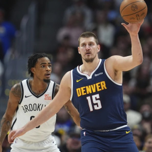 Nikola Jokic (15), de los Nuggets de Denver, recibe un pase, con la marca defensiva de Nic Claxton, de los Nets de Brooklyn, en la primera mitad del juego de baloncesto de la NBA.