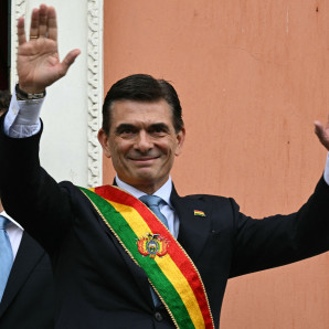 El nuevo presidente de Bolivia, Rodrigo Paz, saluda a sus seguidores junto a su hijo desde un balcón del Palacio Quemado durante su toma de posesión en La Paz el 8 de noviembre de 2025.