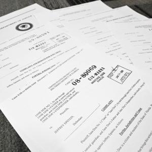 Esta fotoilustración, tomada en Washington, D.C., el 19 de diciembre de 2025, muestra documentos judiciales después de que el Departamento de Justicia de EE. UU. comenzara a publicar los tan esperados registros de la investigación sobre el caso políticamente explosivo del delincuente sexual convicto Jeffrey Epstein.