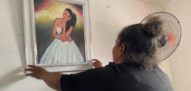 Yenny Hilario, madre de Yanneli, sostiene una foto de su hija en su residencia