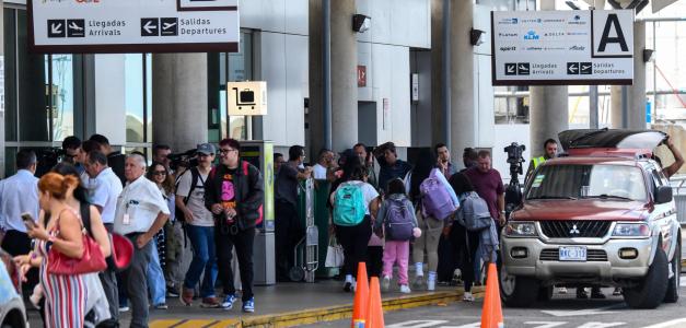 Personas esperan en la entrada del aeropuerto tras la cancelación de vuelos debido a una falla eléctrica que inutilizó el sistema de radar del Aeropuerto Internacional Juan Santa María en Alajuela, Costa Rica, el 24 de septiembre de 2025.
